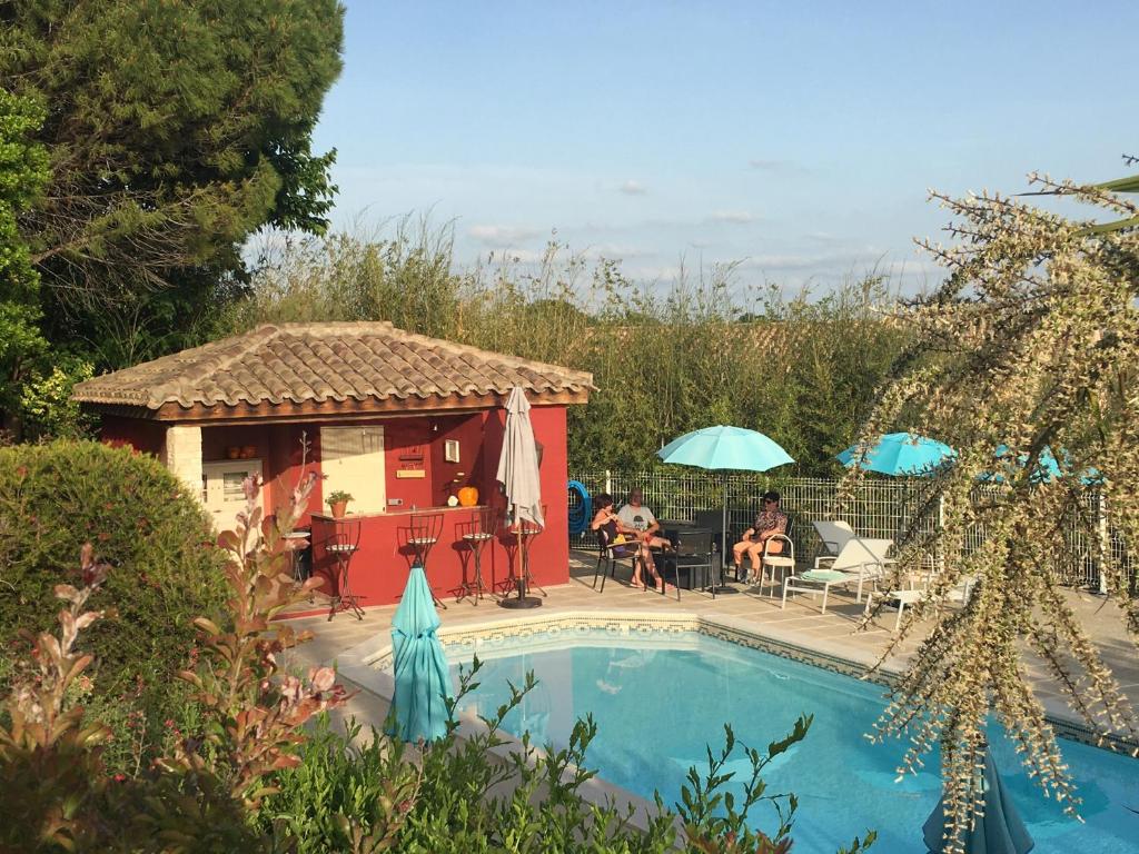 a swimming pool with a gazebo next to a house at Gites Còr Causy OLEANDER in Causses-et-Veyran