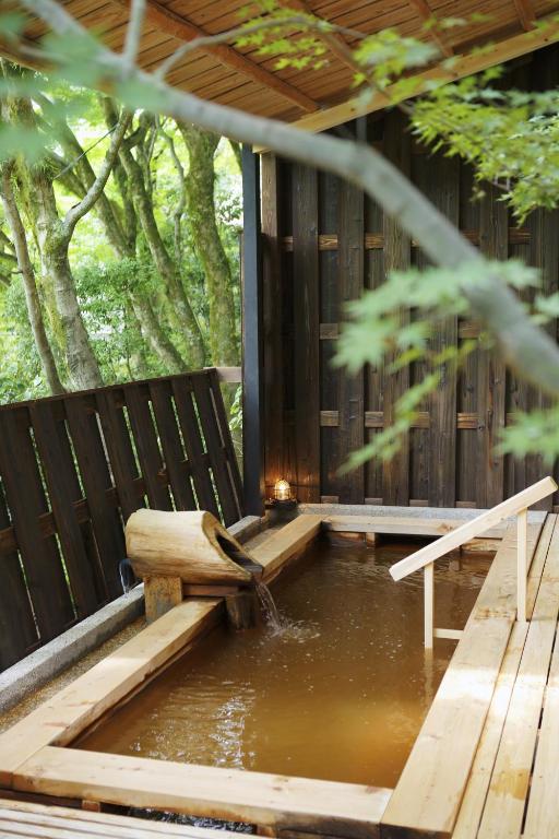 a pool of water next to a wooden bench at Negiya Ryofukaku in Kobe