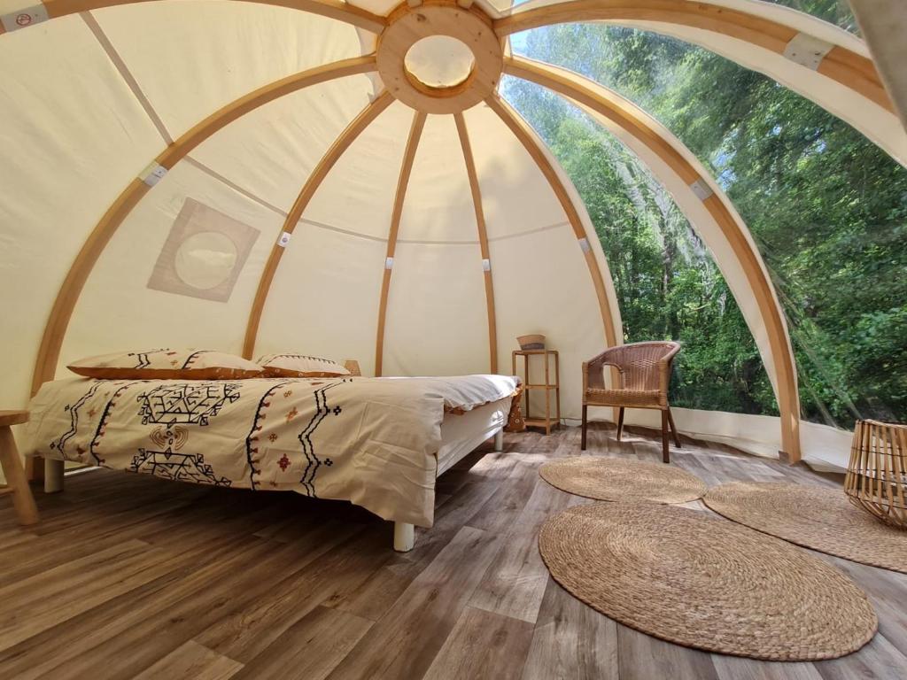 1 dormitorio con 1 cama en una tienda de campaña en la cúpula en La Wigwam Blanche du Domaine du Pas de l'âne, en Mios