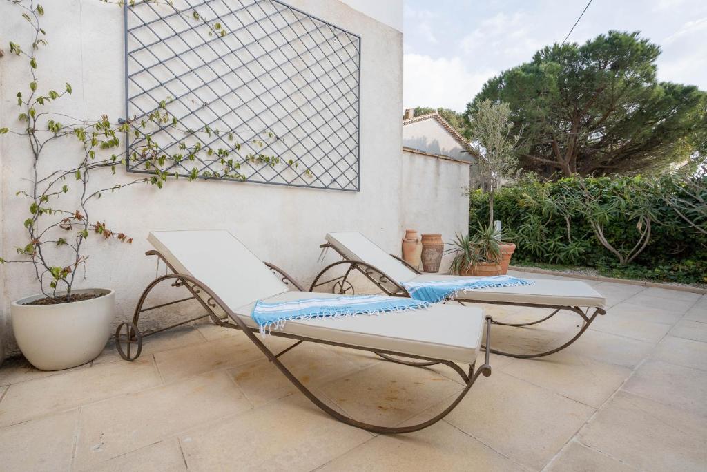 two chairs and a table on a patio at Hôtel Le Méditerranée in Hyères