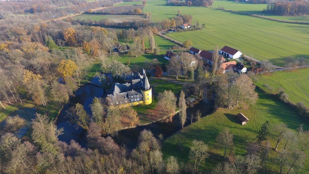 eine Luftansicht einer Burg auf einem Feld in der Unterkunft Schlosspark Hollwinkel in Preußisch Oldendorf