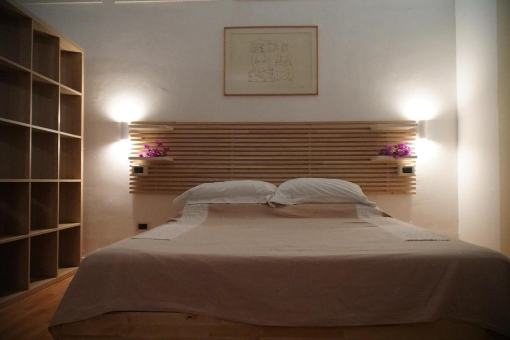 una camera da letto con un grande letto con due cuscini di Ampio monolocale in villa con giardino a Ischia