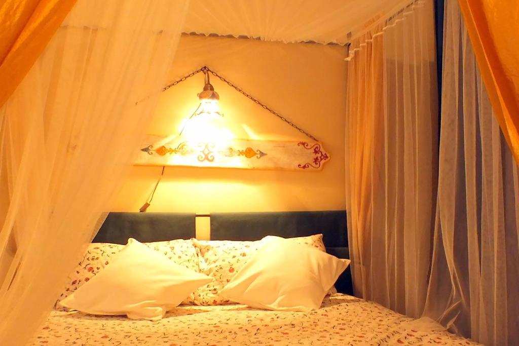 een slaapkamer met een bed met een licht erboven bij Agata di Mare in SantʼAgata di Militello