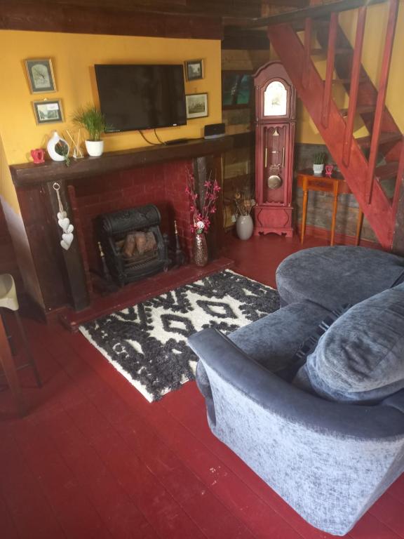 a living room with a couch and a fireplace at Yarm cottages the rafters in Kirk Leavington