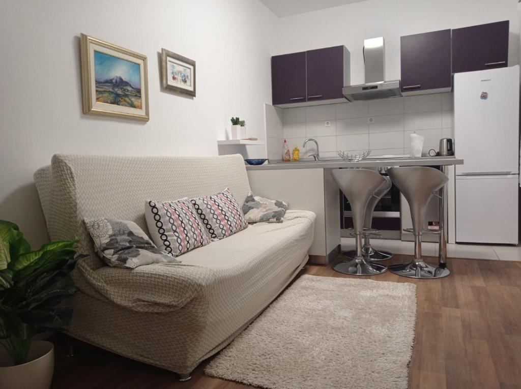 Il comprend un salon avec un canapé et une cuisine. dans l'établissement Apartments Bride's Rock, à Baška Voda