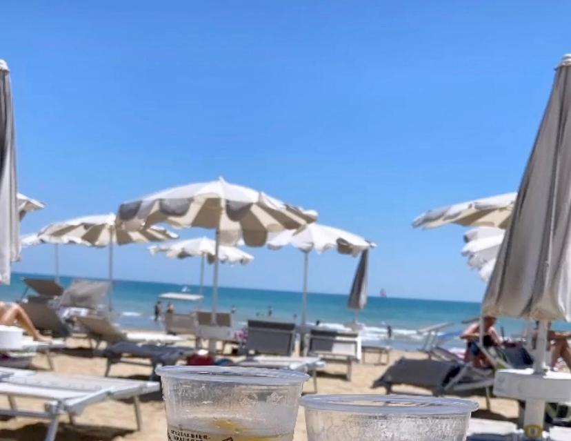 una playa con sombrillas y sillas y el océano en Le terrazze vista mare, en Lido di Jesolo