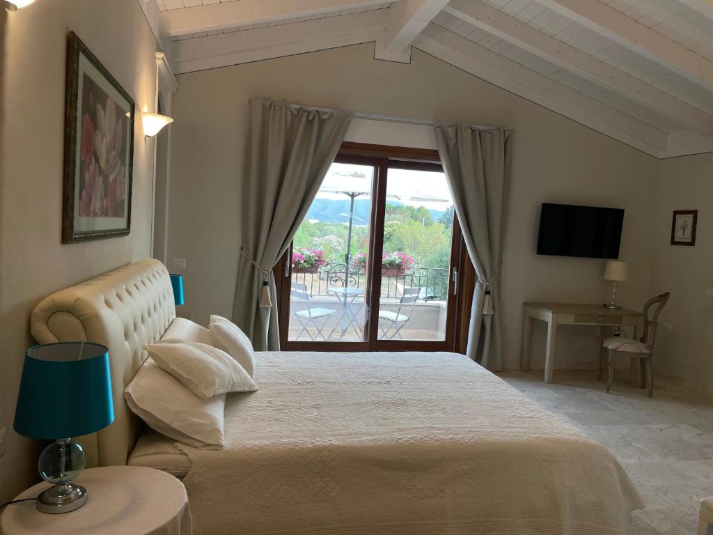 een slaapkamer met een groot bed en een raam bij Corte dei Mirti, camere signorili in Iglesias