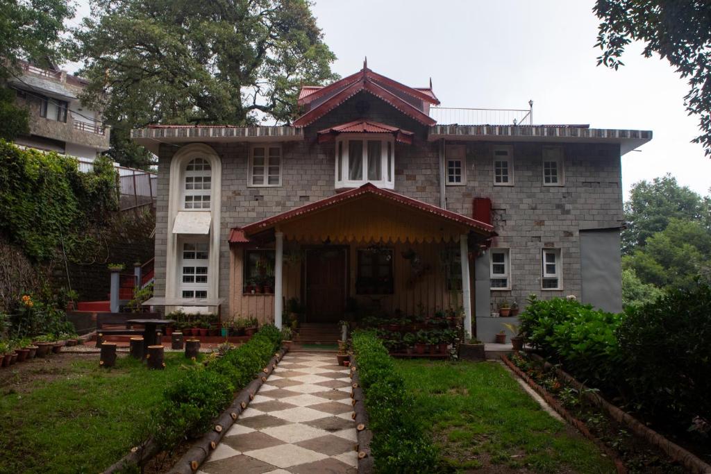 an old house with a checkered floor in front of it at The Hilltop Haven in Nainital