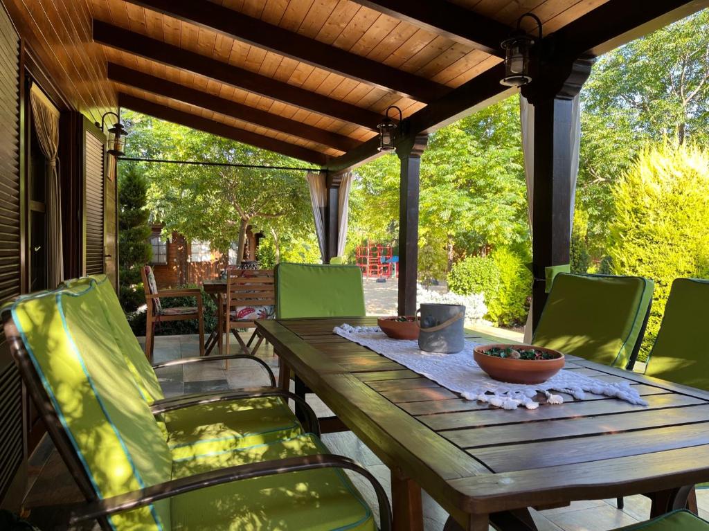 Une table et des chaises en bois sont disponibles sur la terrasse. dans l'établissement Casa Rural con Encanto CABAÑA EL SALSE, 