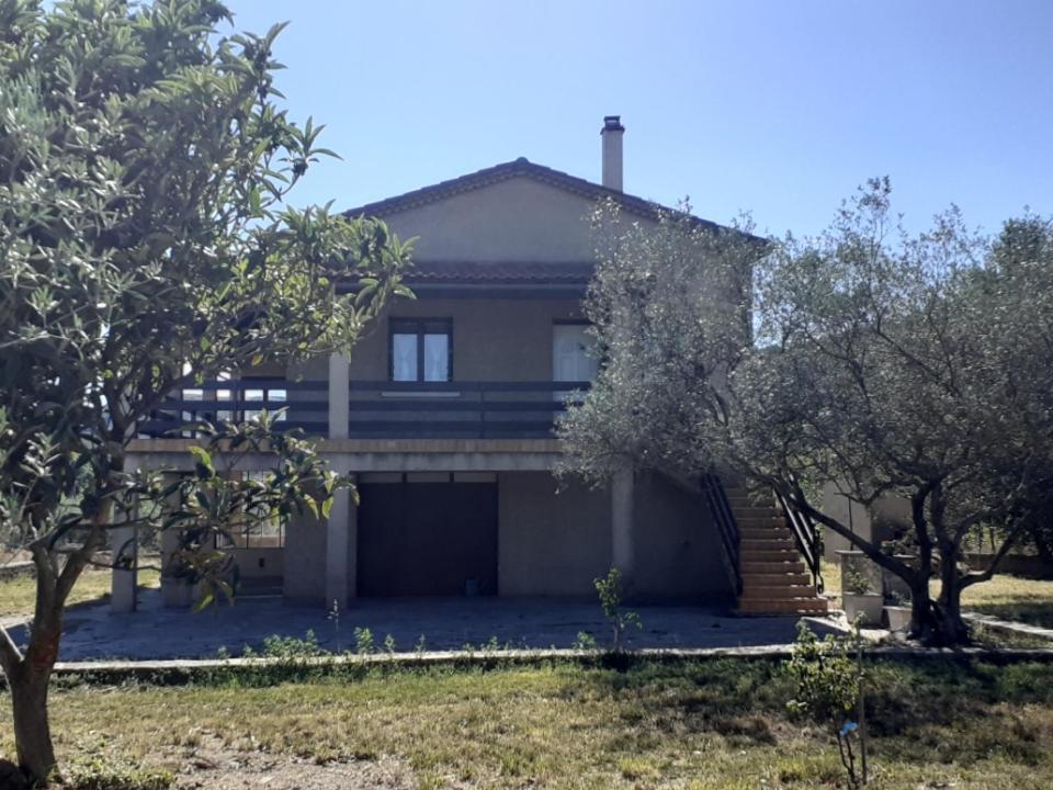 dom z garażem i drzewami przed nim w obiekcie Jolie maison à louer dans les Cévennes w mieście Saint-Christol-lès-Alès