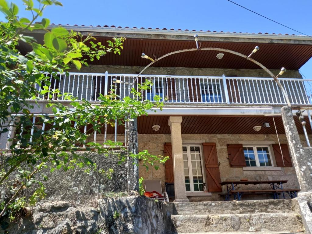una casa con balcón y escaleras delante en Casa Anita - Ribeira Sacra, en Os Peares