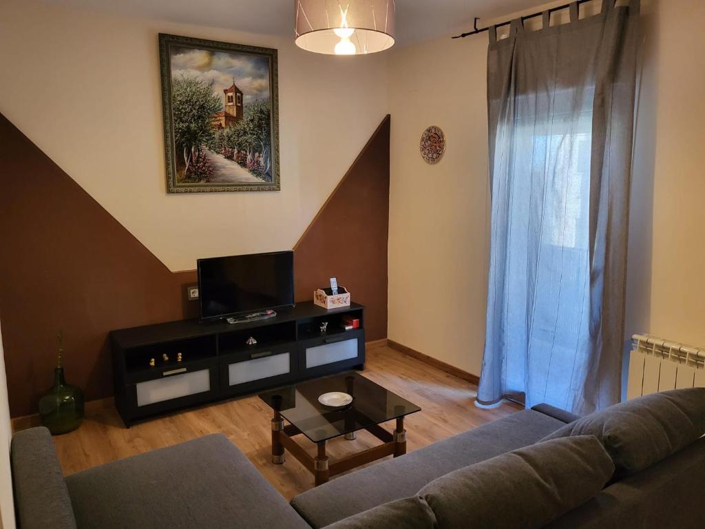 a living room with a couch and a tv at La casa de Las Navas in Las Navas del Marqués
