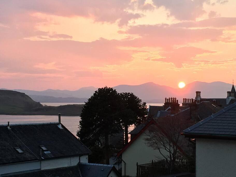 a sunset over a town with houses and a lake at Edgemont Annexe Oban in Oban