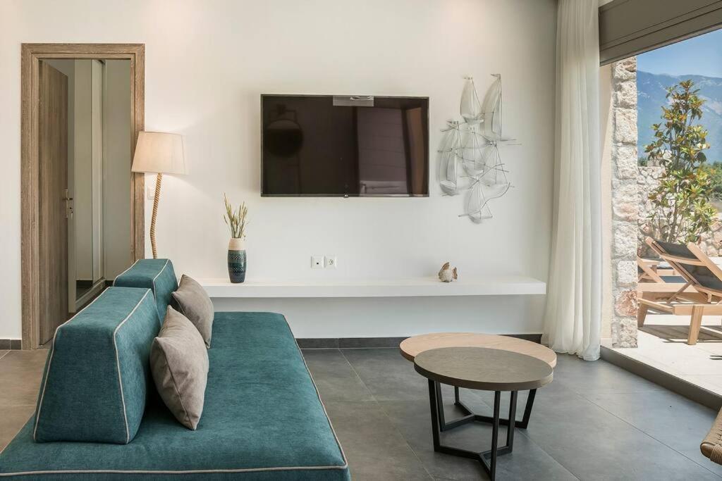 a living room with a blue couch and a table at Villa Amarylis - Ionian Treasure Villas in Kefallonia