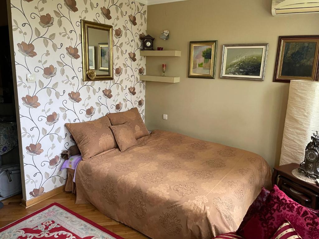 a bedroom with a bed and a wall with flowers at Apartment Ljiljana in Belgrade