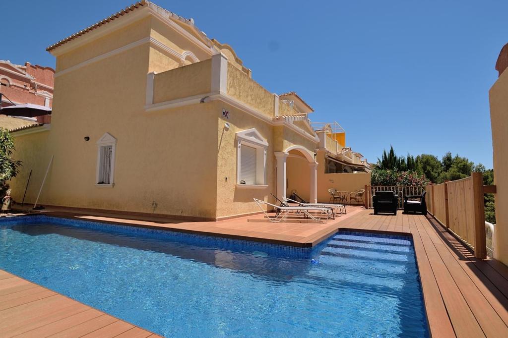 a villa with a swimming pool in front of a house at Casa Felicidad in Calpe