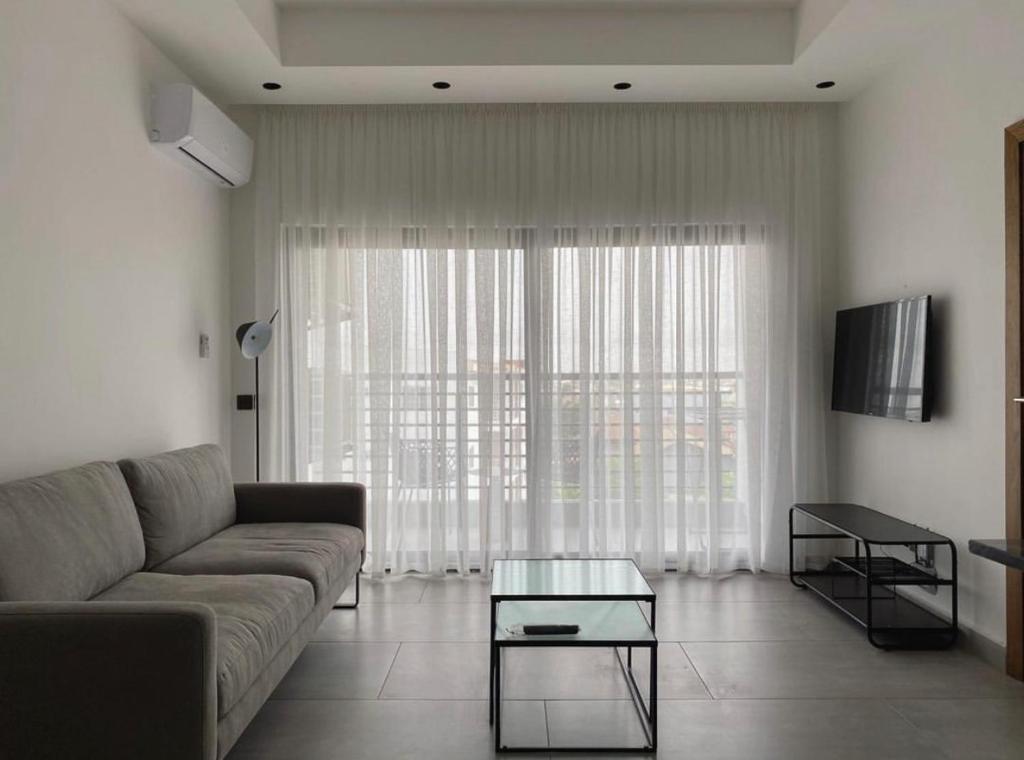 a living room with a couch and a glass table at Luxurious 1 bedroom space in Accra