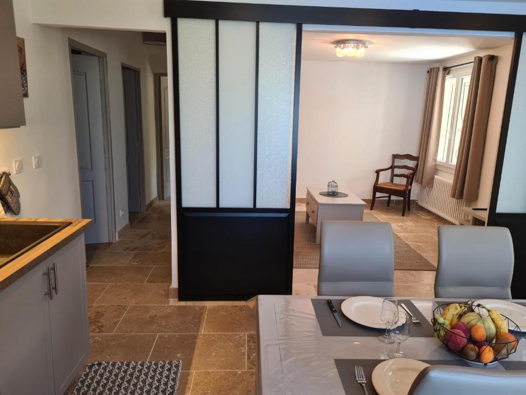 a kitchen and dining room with a table with a bowl of fruit at les olivades in Cavaillon