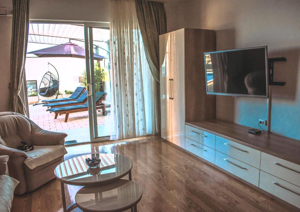Televízia a/alebo spoločenská miestnosť v ubytovaní Apartment with private pool "Patricia"