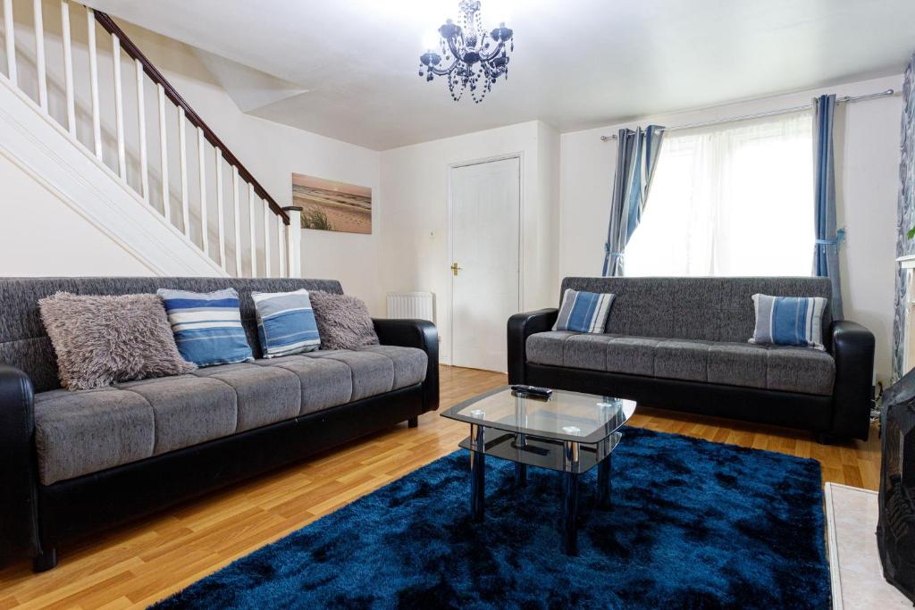 a living room with a couch and a table at 4 beds Sleeps 5- Elegance Leisure Stay, Oldham in Lees