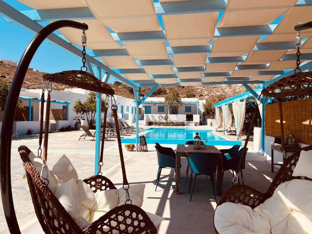 a patio with a table and chairs and a pool at Family Villages Santorini in Vlychada Beach