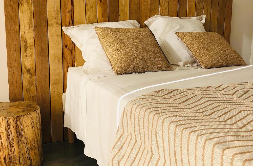 1 dormitorio con 1 cama con sábanas y almohadas blancas en L’Eden sur la Colline, en Peypin