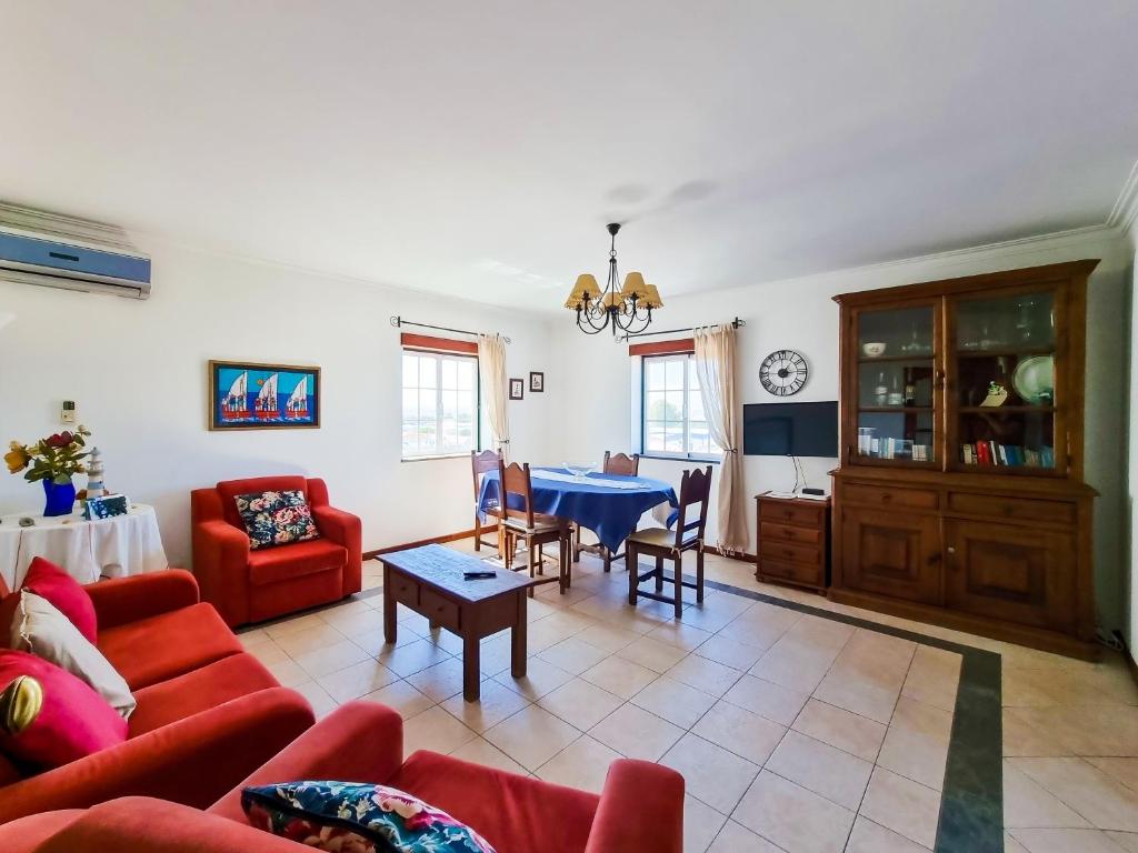 ヴィラ・レアル・デ・サント・アントニオにあるFLH Vila Real Santo António Marina Apartmentのリビングルーム(赤いソファ、テーブル付)
