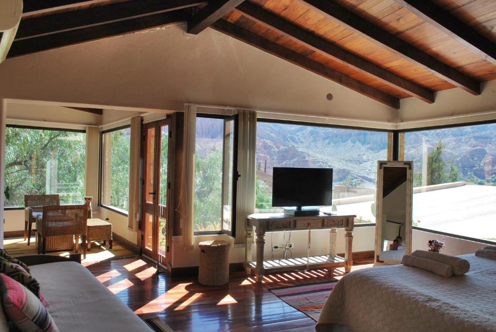 ein Wohnzimmer mit einem TV und einigen Fenstern in der Unterkunft Santa Lucia in Tilcara