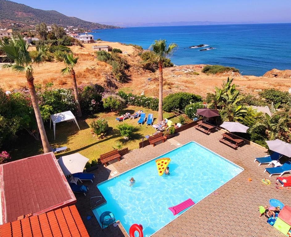 an overhead view of a swimming pool and the ocean at Kanalli Apartments in Pomos