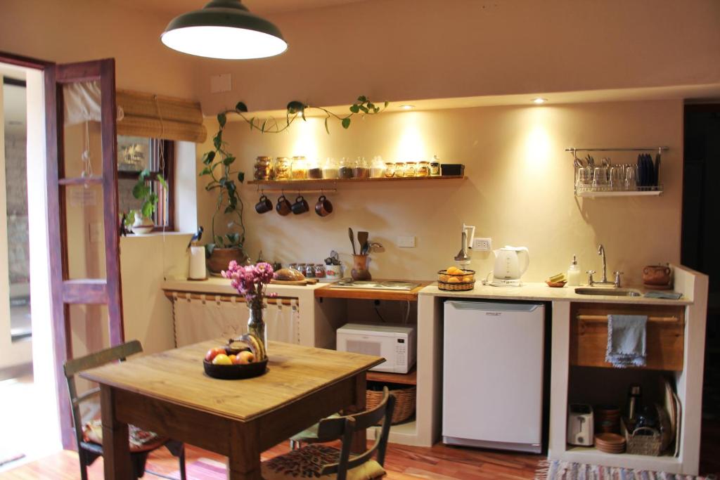 a kitchen with a wooden table and a table and a dining room at Apartamento en el vivero in Tilcara