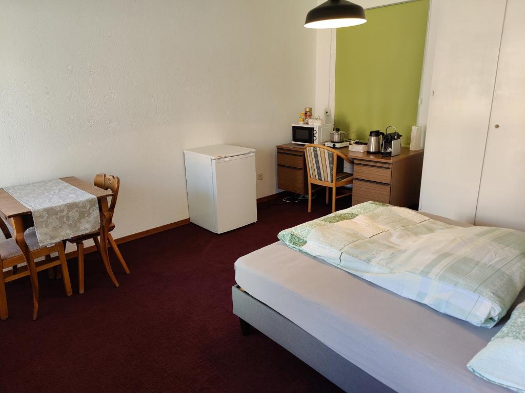 a room with a bed and a table and a kitchen at 1 Zimmer Studio mit Kitchenette in Bad Ragaz
