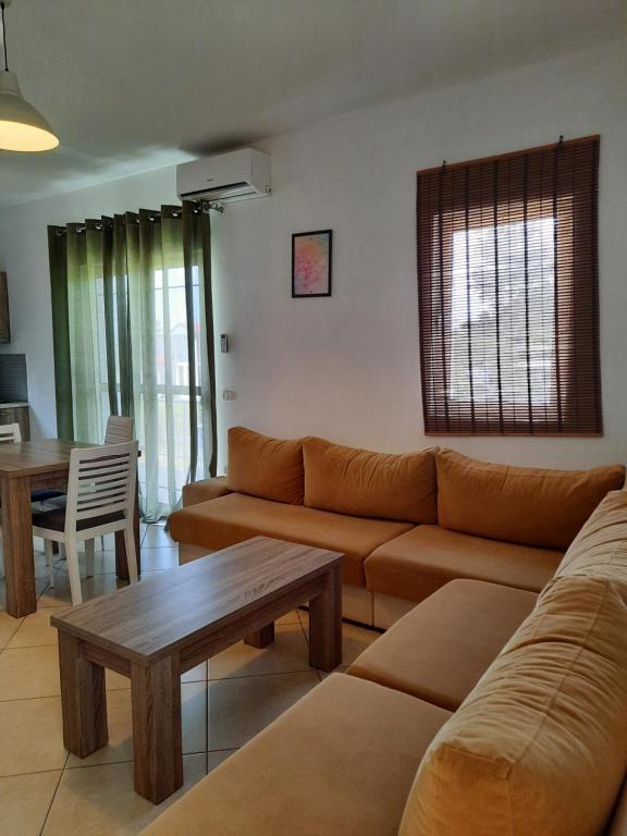 sala de estar con sofá y mesa en Apartments Alavana, en Velipojë