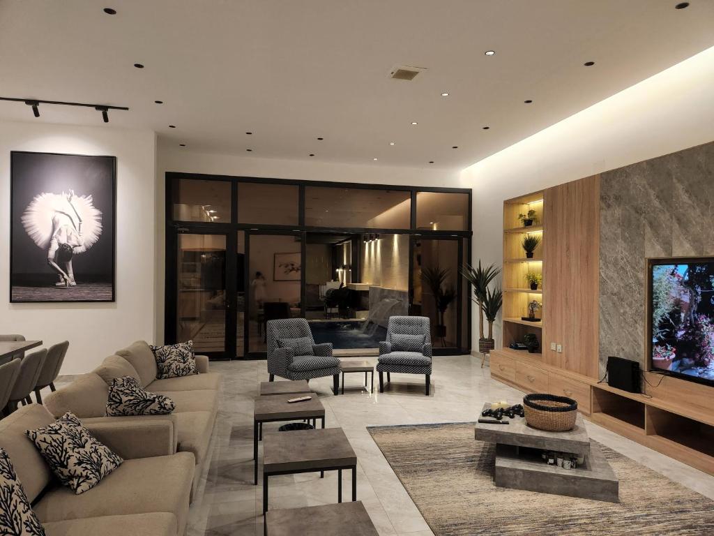 ein Wohnzimmer mit einem Sofa und einem TV in der Unterkunft شاليه فاخر جداً جداً وخاص in Riad