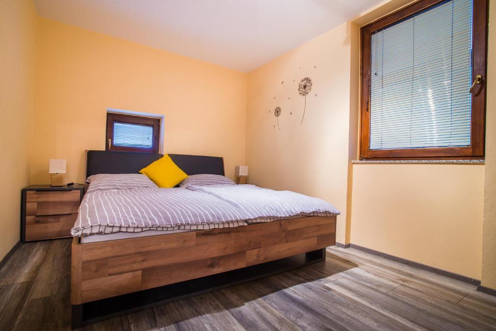 een slaapkamer met een houten bed met een geel kussen bij Apartment Veninsek in Luče