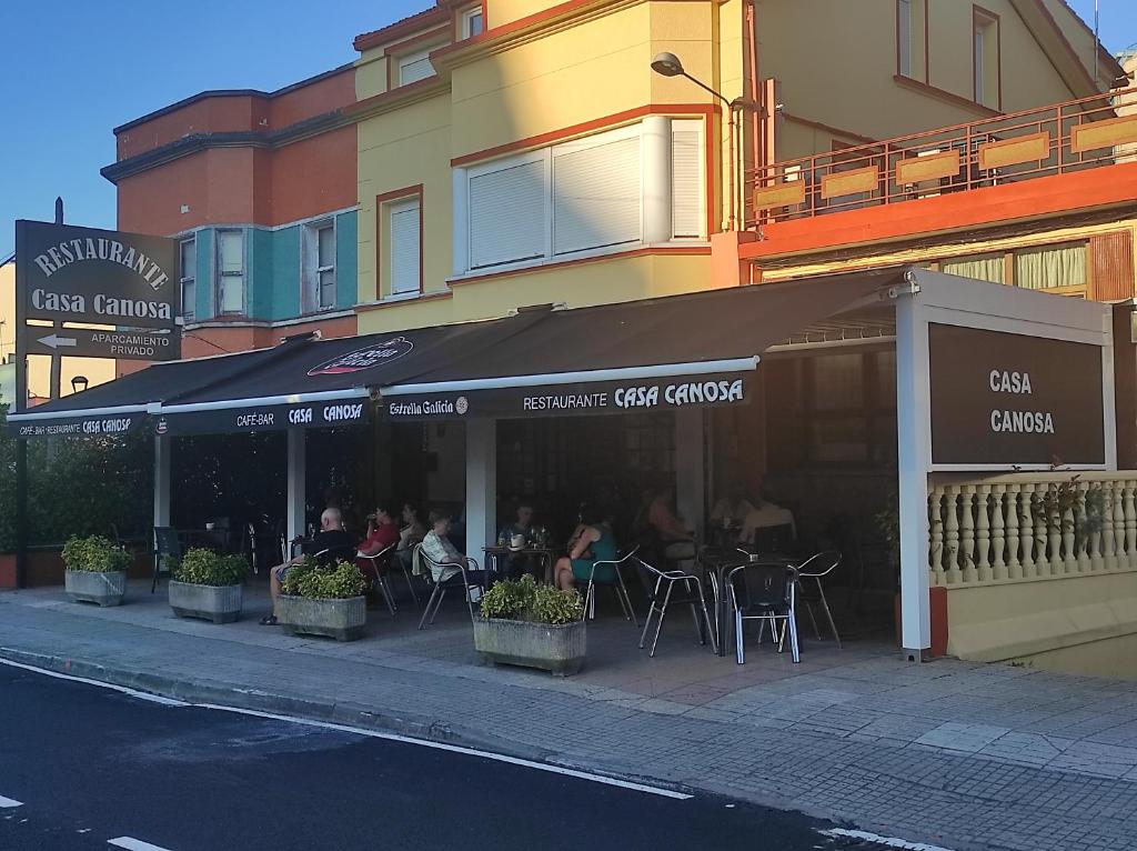 ein Restaurant mit Tischen und Stühlen in einer Stadtstraße in der Unterkunft Casa Canosa in A Coruña
