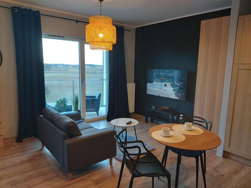 a living room with a couch and a table with chairs at Aparthotel - Buk in Buk