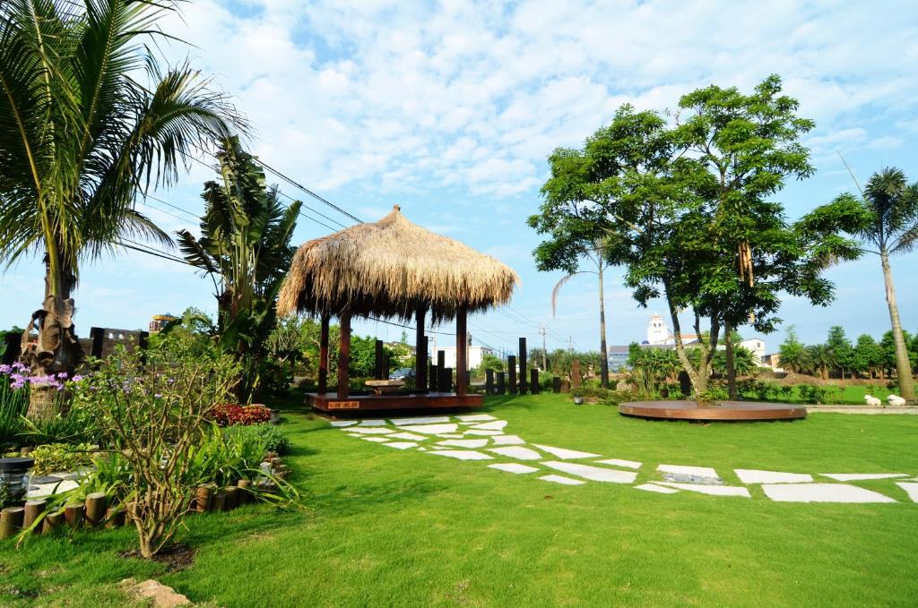 a grassy yard with a gazebo and palm trees at Full Sweet Inn in Wujie