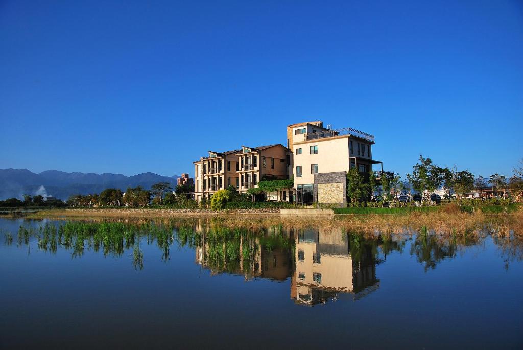 a building sitting next to a body of water at Full Sweet Inn in Wujie