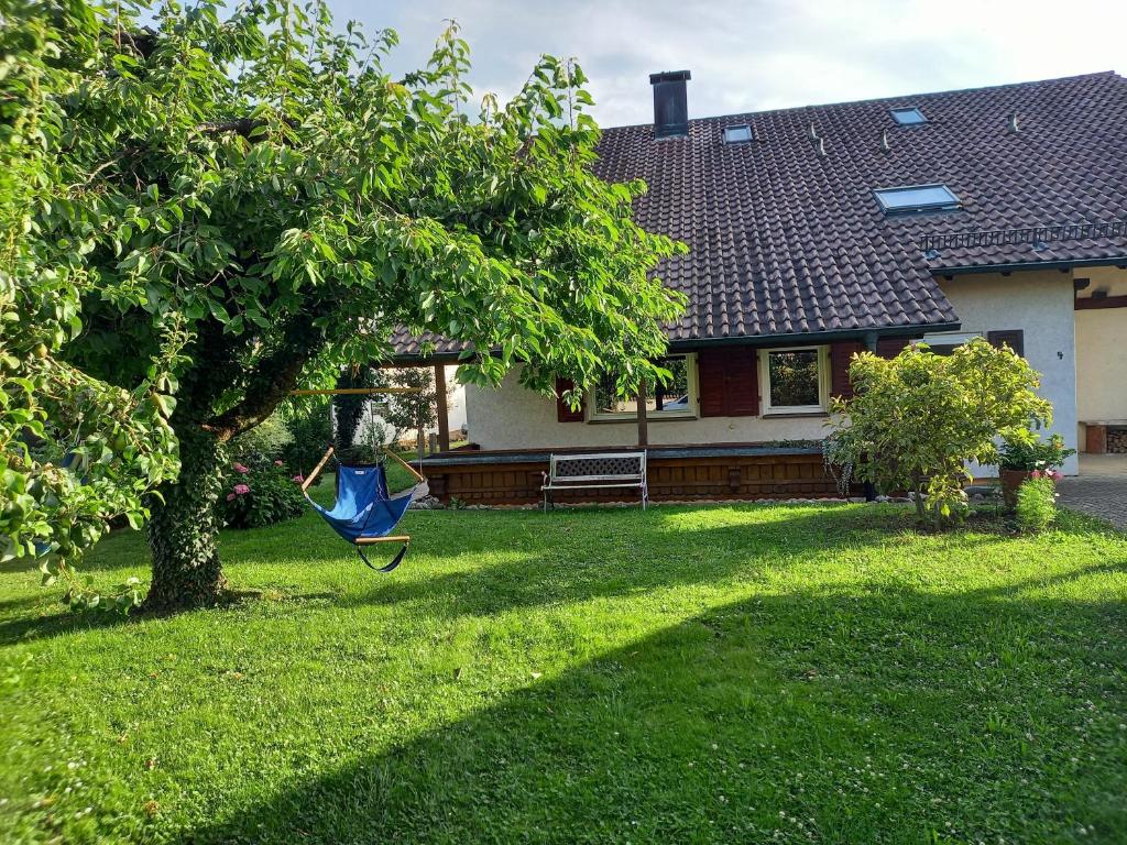una hamaca colgando de un árbol delante de una casa en Ferienwohnung Riposo en Meersburg