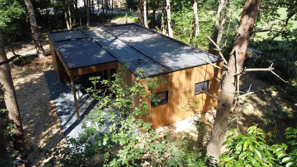 Vakantiewoning De Kleine Duinberg - Chalet Nr 9 في ريتي: منزل خشبي صغير في وسط غابة