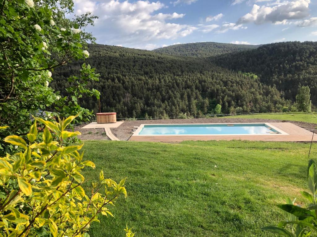 a swimming pool in the middle of a grass field at La Borda del Feu in Guardia de Arés