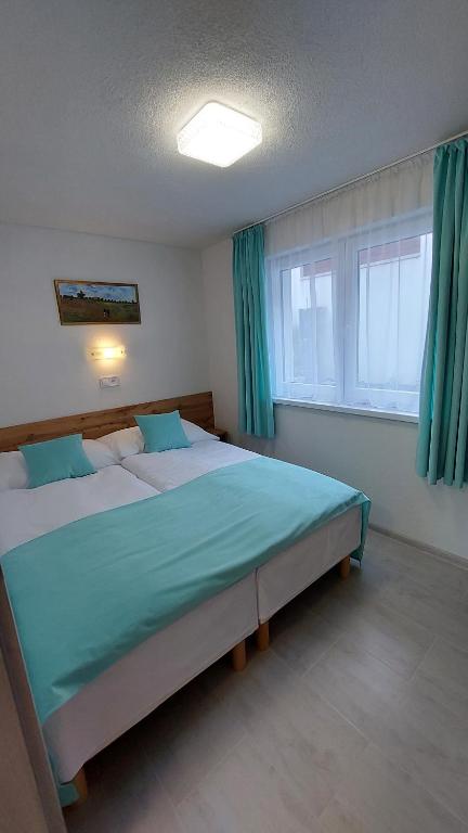 sypialnia z dużym łóżkiem z niebieską pościelą w obiekcie Apartmány nad Tajovom w Bańskiej Bystrzycy