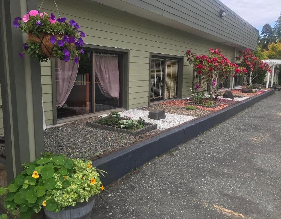 une maison avec des fleurs sur son côté dans l'établissement Airport Inn, à Port Hardy