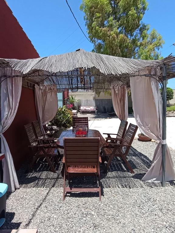 patio ze stołem i krzesłami pod baldachimem w obiekcie Home Benitez Pizarra w mieście Pizarra
