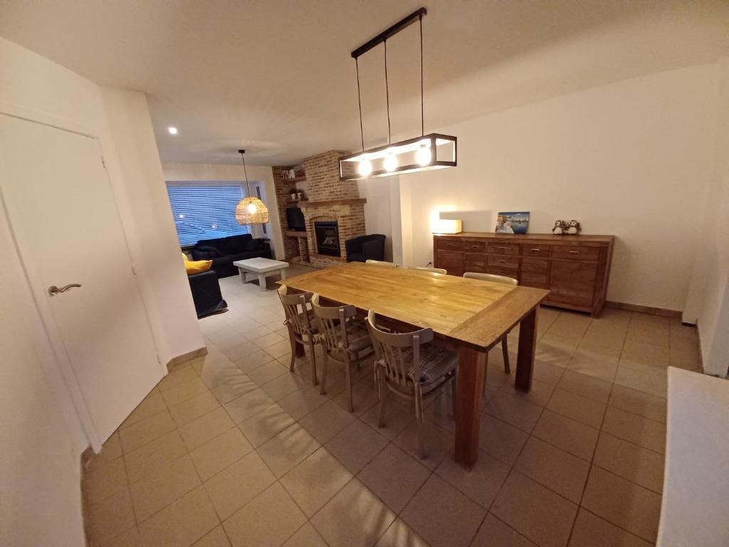 una cucina e una sala da pranzo con tavolo e sedie in legno di Toffe woning dichtbij zee, bos en natuur a De Panne