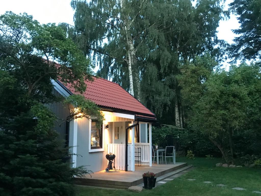 una pequeña casa blanca con techo rojo en Tobisborg 1 Simrishamn, en Simrishamn