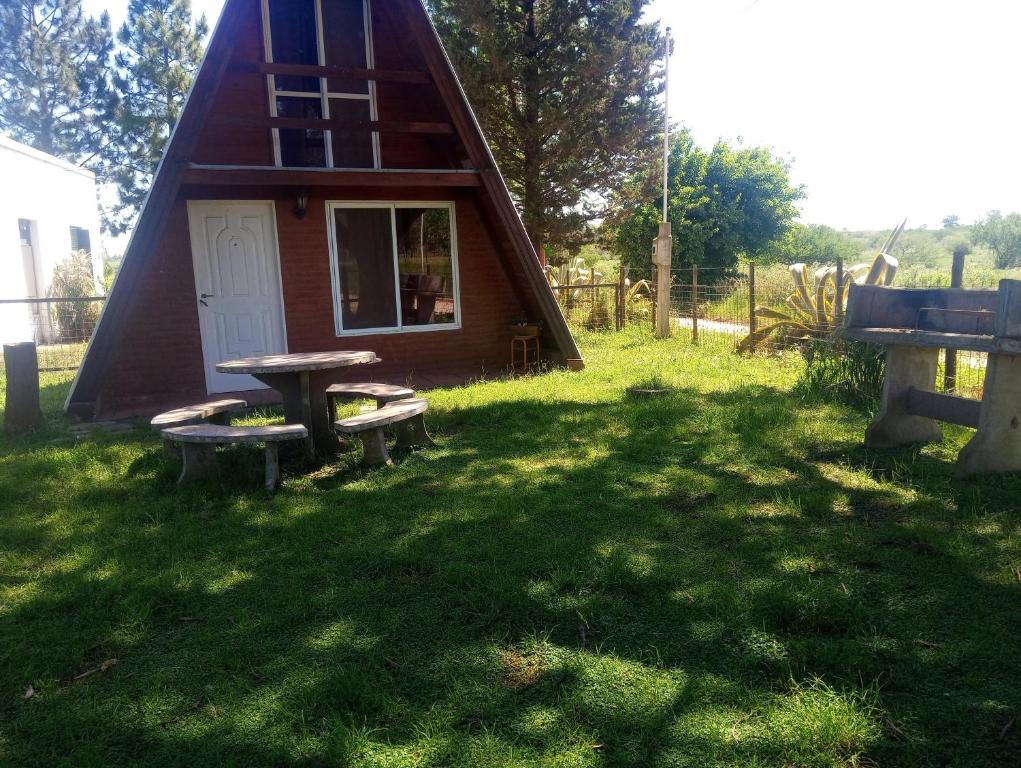 una pequeña casa con una mesa de picnic en el césped en Paraje del Molino Casa Alpina, en San José