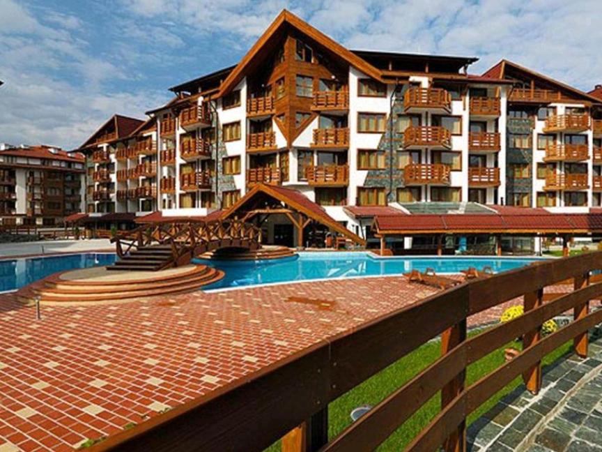 ein großes Apartmenthaus mit einem Pool davor in der Unterkunft Belvedere Holiday Club Private Apartment in Bansko