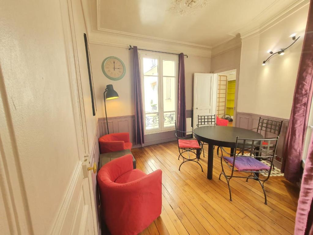 une salle à manger avec une table et des chaises rouges dans l'établissement Home Sweet Home La Chapelle, à Paris