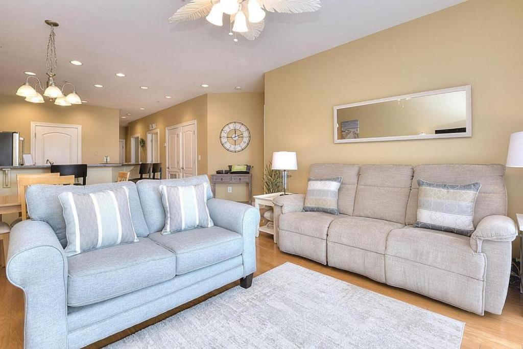 ein Wohnzimmer mit 2 Sofas und einer Küche in der Unterkunft Rock N Reel in Oak Island